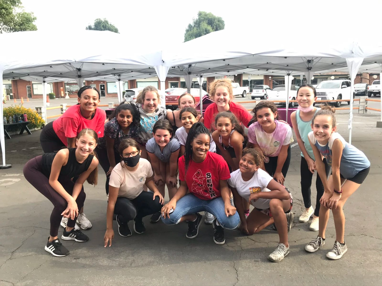Our dancers together outdoors under the canopies at a community event.