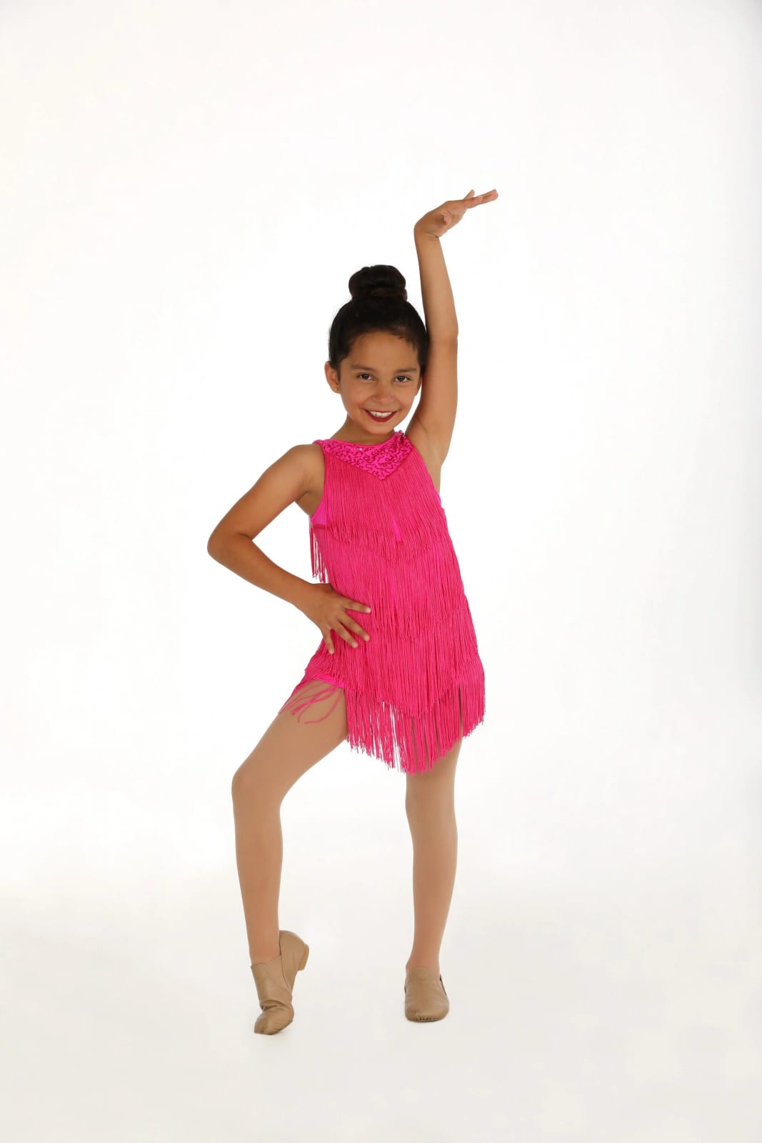 A musical theatre dancer in a pink fringe dress on the white studio backdrop.