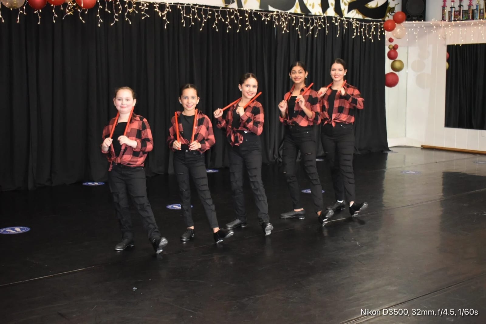 A line of dancers in plaid shirts performing at one of our showcases.