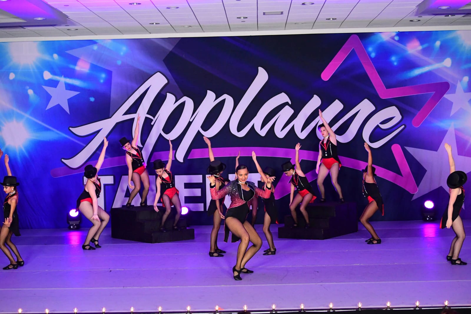 A jazz group performing in front of a lit Applause Talent competition backdrop.