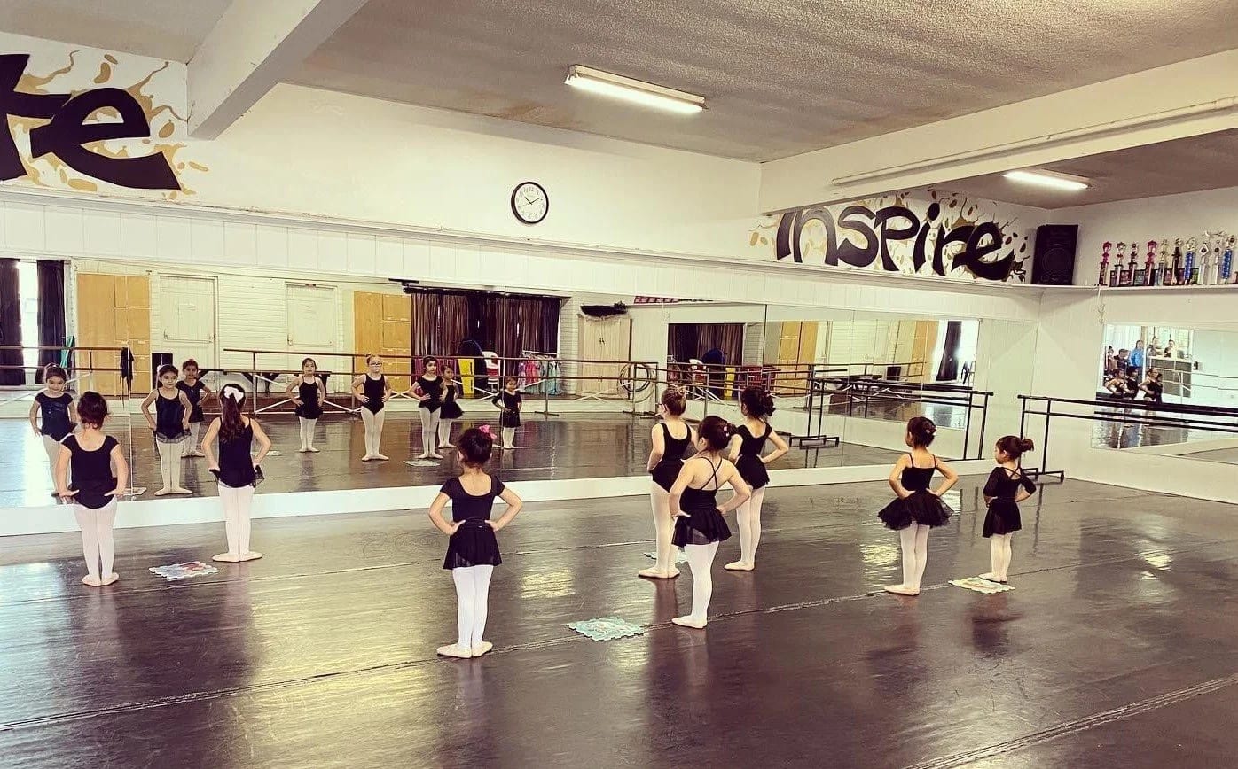 Our petite ballerinas lined up on the studio floor in front of the mirrors and barres.